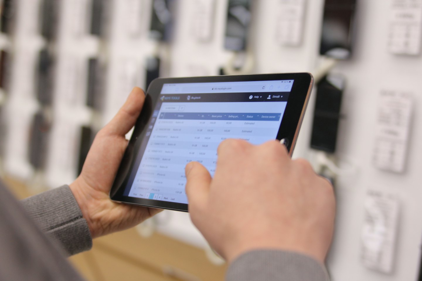 Hands using a tablet to manage inventory and sales.